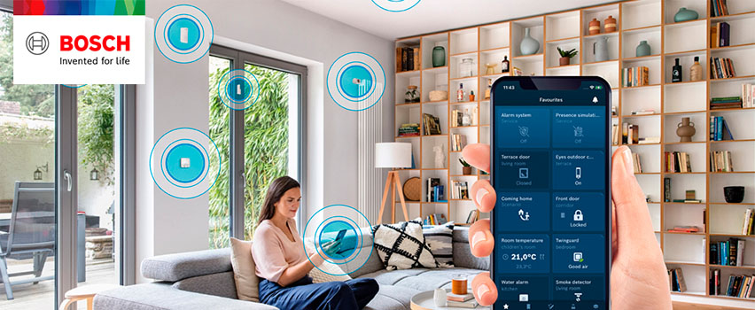 Bosch Smart Home-app visar favoriter som larm, dörrar, rumstemperatur och brandvarnare i smart hem med kvinna i soffa