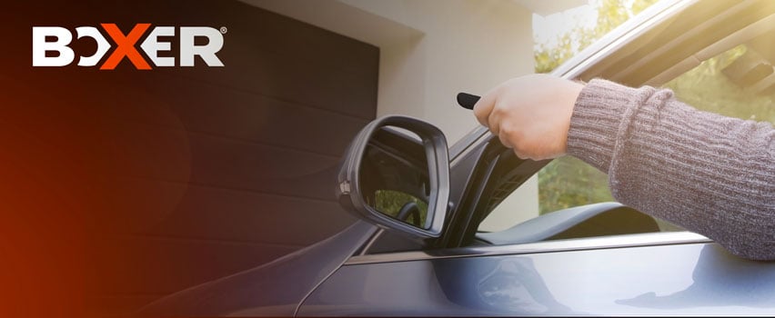 Boxer garageportöppnare – person öppnar automatisk garageport med fjärrkontroll från bilen