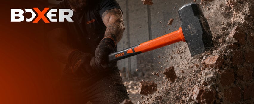 Boxer slägga med orange skaft – hantverkare bryter ned betongvägg med tungt Boxer slagverktyg