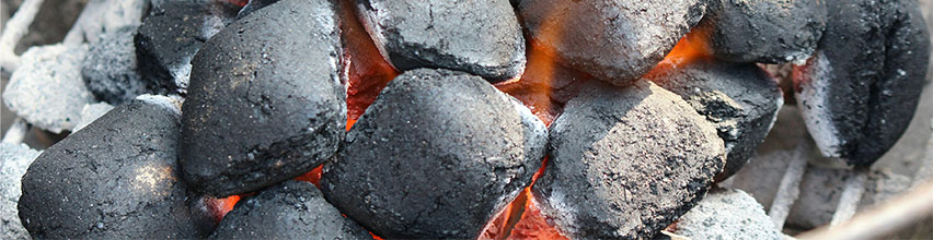 Varma grillkol med glöd och eld i en kolgrill.