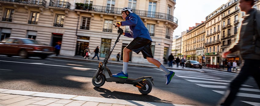 Man kör Navee ST3 Pro elsparkcykel med robusta däck och premiumdesign i kvällsljus