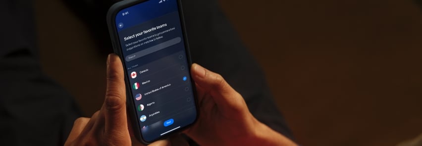 Grupp vänner jublar och firar fotbollsmål i vardagsrummet med dynamisk Philips Hue Sports Live-belysning i röda färger