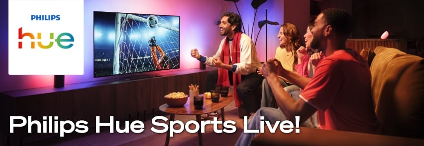 Philips Hue Sports Live – vänner tittar på fotbollsmatch på TV med färgrik Philips Hue smart-belysning i vardagsrummet