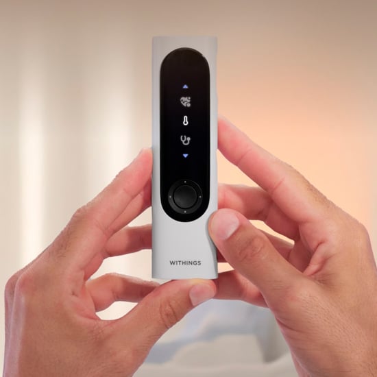 WWithings hälsomätare – hand håller Withings multifunktionell hälsoskanner för mätning av temperatur och hälsodata