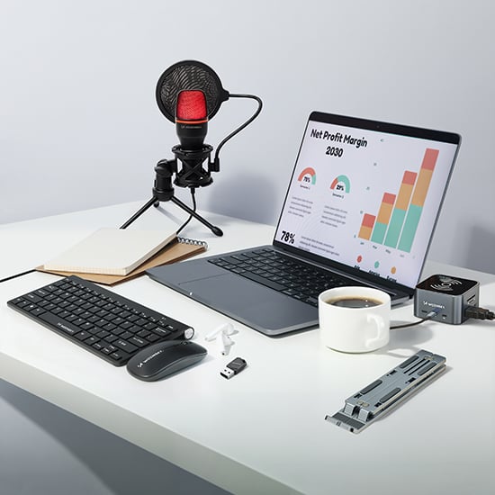 Wozinsky datortillbehör med tangentbord, mus, mikrofon, laptopställ och kaffekopp på ljust skrivbord