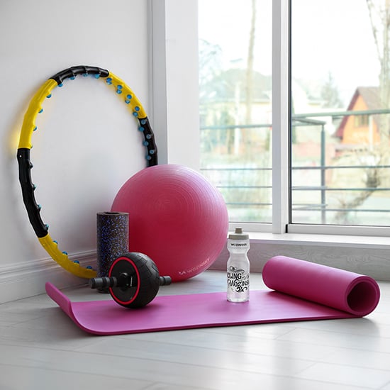 Wozinsky sport- och fitnessutrustning med rosa yogamatta, boll, hula-hoop, skumrulle och vattenflaska vid fönster